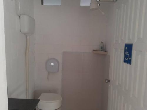 a bathroom with a white toilet in a room at Chácara Rancho da Felicidade in Mogi das Cruzes