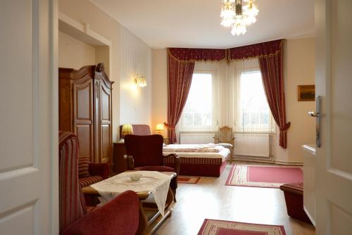 a room with a living room with a bed and a table at Korona Vendégház in Mátészalka