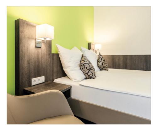um pequeno quarto com uma cama e uma cadeira em Im Tal 2 Apartment WH2 OG em Bergheim
