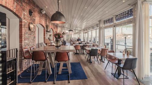 a restaurant with tables and chairs and a brick wall at Quality Hotel Waterfront in Gothenburg