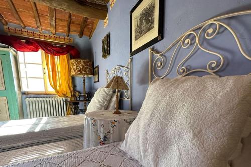 ein Schlafzimmer mit einem Bett und einem Tisch mit einer Lampe in der Unterkunft Borgo Bucatra Proprietà in Lucca