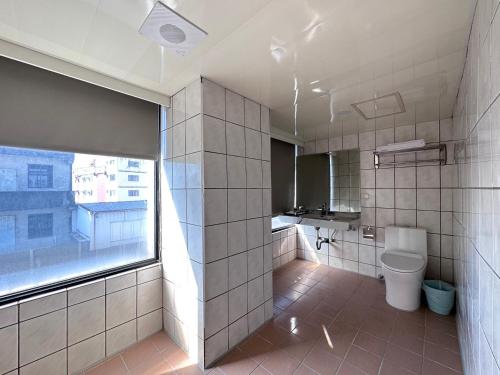 ein Bad mit einem WC und einem großen Fenster in der Unterkunft 可青大飯店Grand Ke-Cing Hotel in Yilan