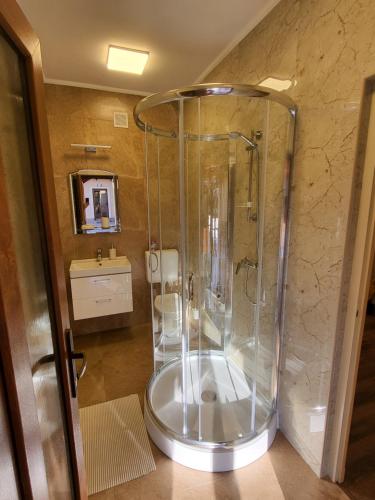 La salle de bains est pourvue d'une douche, de toilettes et d'un lavabo. dans l'établissement Glória Apartman Szarvas, à Szarvas