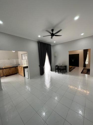 a living room with a ceiling fan and a table at D’Asam Homestay Baling in Baling
