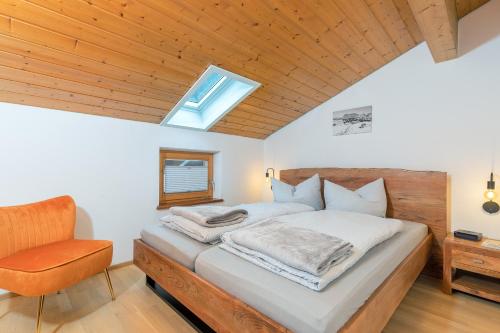 a bedroom with a bed and a chair at Ferienwohnungen Marietta in Reit im Winkl