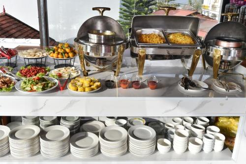 a buffet of food on a shelf with plates at Sapa Nature View Hotel in Sa Pa
