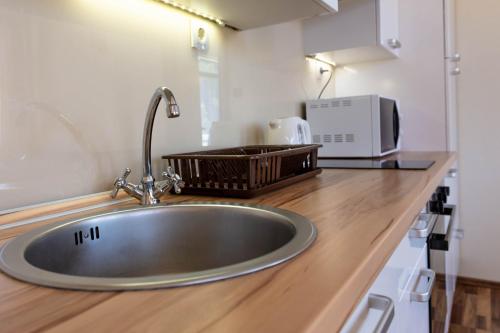 a kitchen counter with a sink and a microwave at By the sea West Apartments in Kaštela