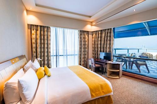 Habitación de hotel con cama grande y balcón. en Elite Resort & Spa, en Manama