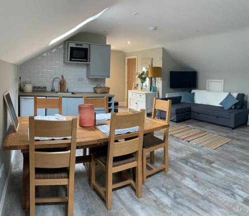 a kitchen and living room with a wooden table and chairs at Luxury rural retreat near Rutland water in Greetham