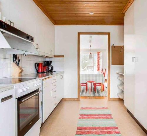 a kitchen with white appliances and a dining room at Mysigt hus med 9 sovrum nära natur och SCA & Hamn in Holmsund