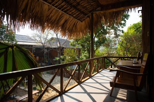 a balcony of a resort with a table and chairs at Muonglo Farmstay in Yên Bái