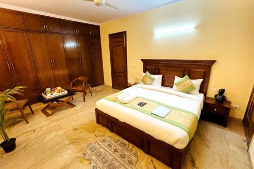 1 dormitorio con 1 cama grande y 1 mesa en Fortune Home Service Apartment 4Bhk,D-36, Saket en Nueva Delhi