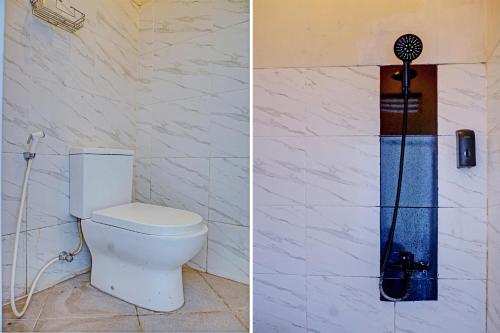 a bathroom with a toilet and a shower at Capital O 93345 The Saka Guest House Syariah in Bandar Lampung