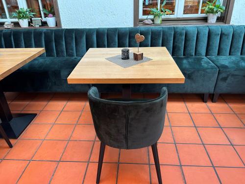 a wooden table and a black chair in a coffee shop at Hotel-Gasthof Löwen in Feldkirch