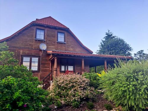 una casa de madera con techo de gambrel en Skrawek Nieba Mostki, en Suchedniów