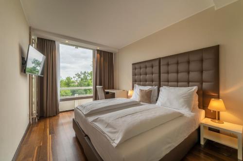 a bedroom with a large bed and a large window at Pakat Residences in Vienna