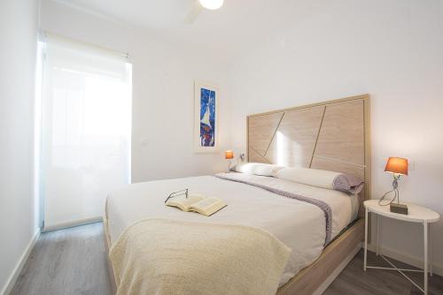a white bedroom with a large bed and a window at Apartamento Natsu - PlusHolidays in Calpe