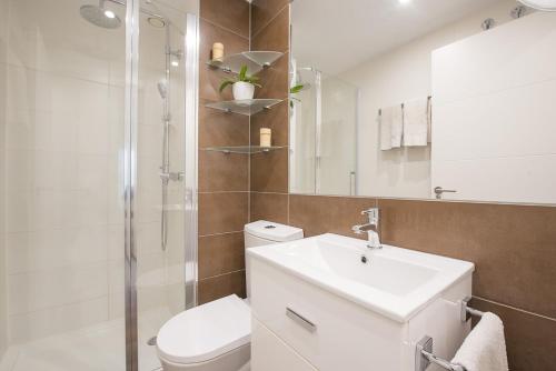 een badkamer met een toilet, een wastafel en een douche bij Apartamento Natsu - PlusHolidays in Calpe