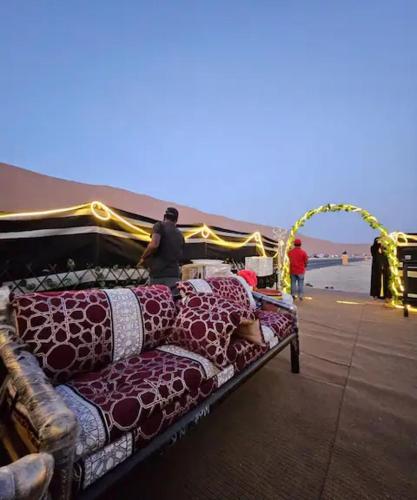 a bed with blankets on it next to the beach at Al khateem Motor Home in Liwa
