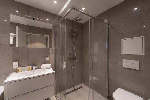uma casa de banho com um chuveiro e um lavatório. em Pakat Residences em Viena