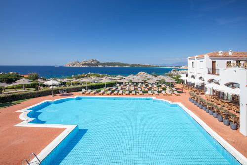 a view of a swimming pool at a resort at Mangia's Santa Teresa Sardinia, Curio Collection by Hilton in Santa Teresa Gallura