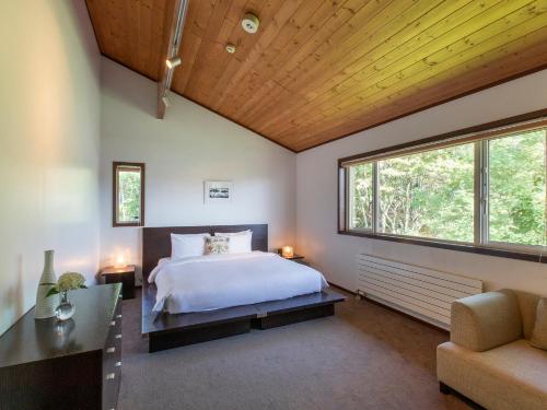 a bedroom with a bed and a large window at Casa La Mount by Elite Havens in Niseko