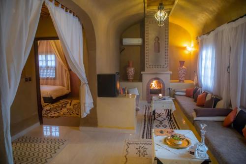 - un salon avec un canapé et une cheminée dans l'établissement Ksar Elkabbaba Kasbah & SPA, à Skoura