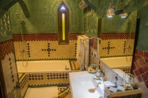 uma casa de banho com um lavatório e uma banheira em Ksar Elkabbaba Kasbah & SPA em Skoura