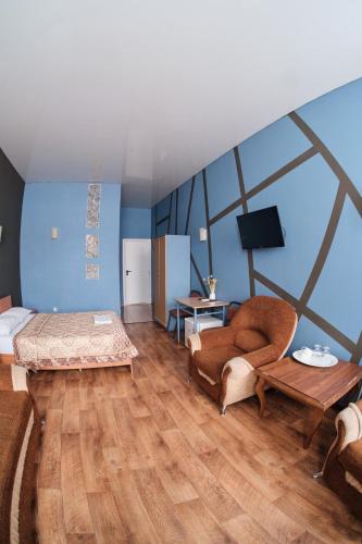 Habitación con cama, sofá y mesa. en Hotel Europa en Semey