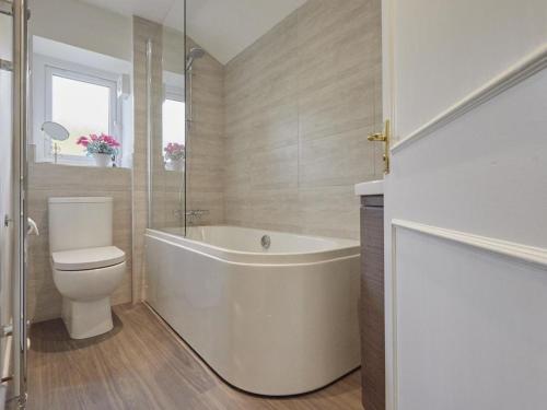 a bathroom with a white tub and a toilet at 2 Bed in Ullswater SZ276 in Stainton