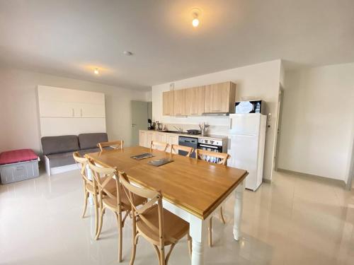 une cuisine et une salle à manger avec une table et des chaises en bois dans l'établissement T3 avec grande terrasse et parking, à Narbonne-Plage