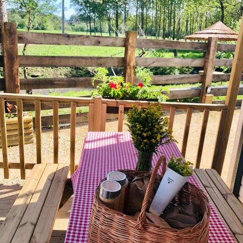 un tavolo da picnic con un cestino e dei fiori su una staccionata di Camping Costa da Morte a Zas