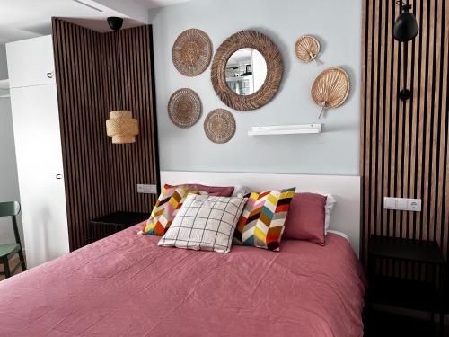 um quarto com uma cama com lençóis cor-de-rosa e um espelho em SG Apartamentos - LA CASA DE SOFÍA VUT-47-14 em Valladolid