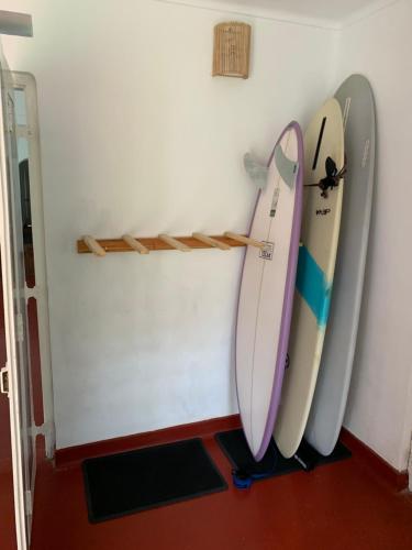 three surfboards leaned up against a wall at Unrushed Midigama in Midigama
