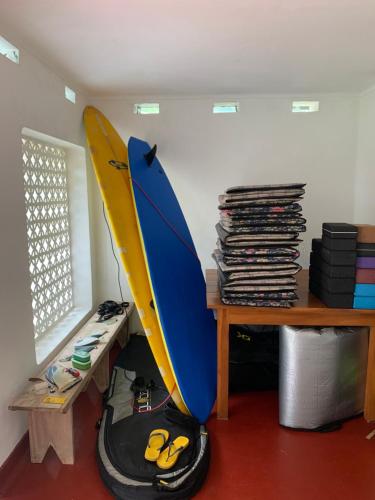 a room with a surfboard sitting next to a table at Unrushed Midigama in Midigama