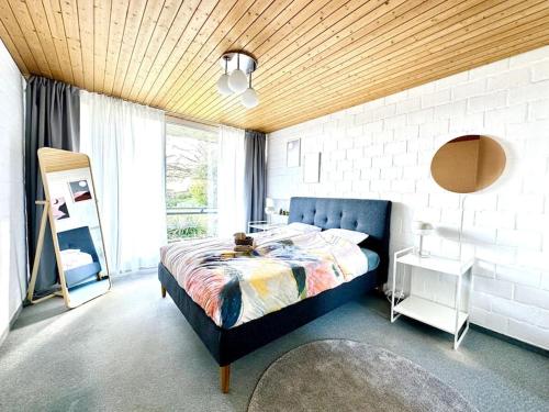 una camera con un letto blu e una finestra di Pool, Jacuzzi, Games, Nature a Adliswil