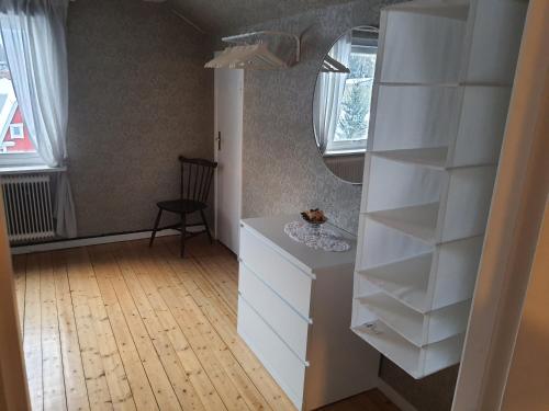 een kamer met een witte dressoir en een spiegel bij Liten lägenhet 2 + 2 pers in Fågelfors