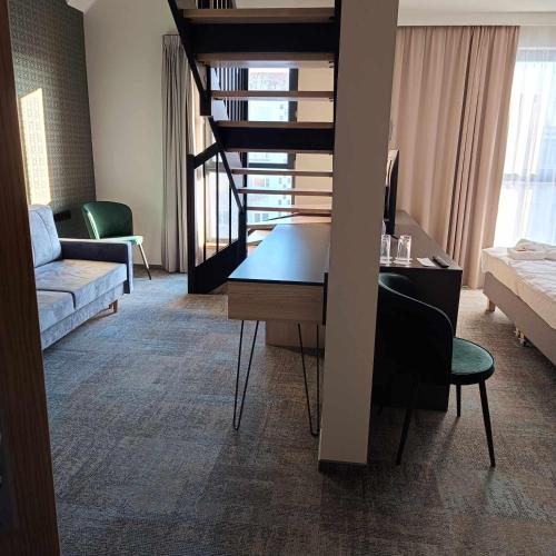 a living room with a desk and a staircase in a room at BULVAR in Malbork