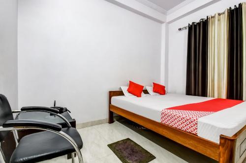 um quarto com uma cama e uma cadeira em OYO Flagship Hotel Capital Hill em Rajgir