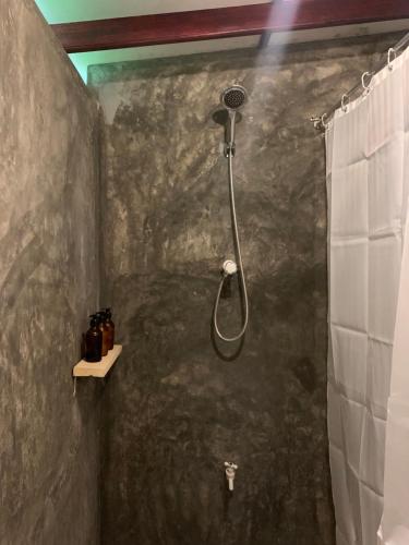 a shower in a bathroom with a stone wall at Unrushed Midigama in Midigama