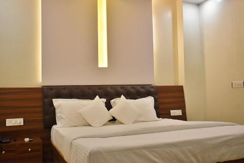 a bedroom with a large bed with white pillows at Hotel Blue Moon Deluxe A Breathtaking stay in Prayagraj