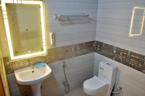 a bathroom with a white toilet and a sink at Hotel Blue Moon Deluxe A Breathtaking stay in Prayagraj