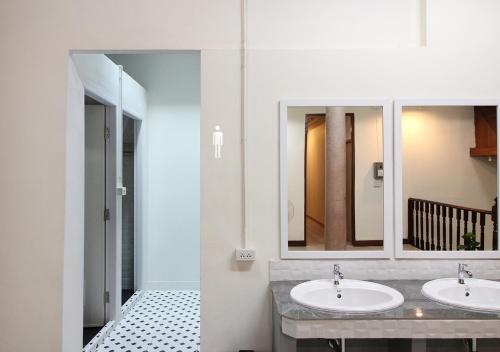 a bathroom with two sinks and a mirror at Chaiwat Hostel in Bangkok