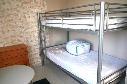 Zimmer mit 2 Etagenbetten, einem Tisch und einem Schreibtisch in der Unterkunft La maison dans le pré in Agon Coutainville