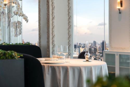 a table with wine glasses on it in a restaurant at lebua at State Tower in Bangkok