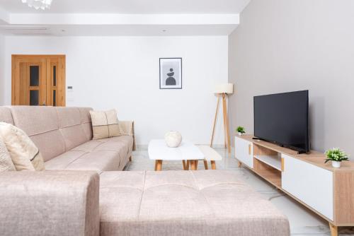a living room with a couch and a flat screen tv at Appartement Luxueux à Draria in Draria