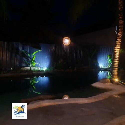 a swimming pool at night with lights on a wall at Cóc Retreat Mỹ Tho City in My Tho