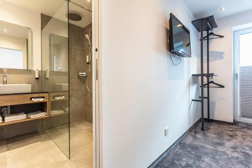 a bathroom with a glass shower and a sink at lechner living apartments in Wald im Pinzgau