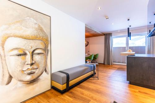 a room with a painting of a face on the wall at lechner living apartments in Wald im Pinzgau