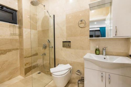 uma casa de banho com um chuveiro, um WC e um lavatório. em Villa Gökkuşağı / Kalkan em Kas